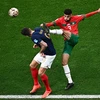 Pha tranh bóng giữa tiền đạo Pháp Olivier Giroud (trái) và hậu vệ Maroc Noussair Mazraoui. (Ảnh: AFP/TTXVN)