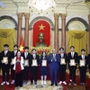 Chủ tịch nước Nguyễn Xuân Phúc tặng ảnh chân dung Chủ tịch Hồ Chí Minh cho các học sinh đoạt giải các cuộc thi Olympic và Khoa học kỹ thuật quốc tế năm 2022. (Ảnh: Thống Nhất/TTXVN)