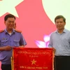 Viện trưởng Lê Minh Trí trao cờ thi đua cho Phòng thực hành quyền công tố và kiểm sát điều tra án kinh tế-chức vụ - Phòng 3 Viện Kiểm sát Nhân dân TP.HCM. (Ảnh: Thành Chung/TTXVN)