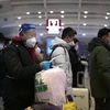 Hành khách xếp hàng chờ lên tàu tại nhà ga ở Bắc Kinh, Trung Quốc. (Ảnh: AFP/TTXVN)