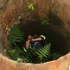 Lực lượng công an triển khai phương án cứu nạn người đàn ông bị rớt xuống giếng sâu. (Ảnh: TTXVN phát)