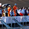 Các đại biểu thả cá xuống lòng hồ thủy điện Sông Tranh 2. (Ảnh: Trịnh Bang Nhiệm/TTXVN)