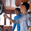 Kiểm ngư kiểm tra thiết bị giám sát hành trình trên các tàu cá đánh bắt trên biển. (Ảnh: TTXVN phát)