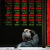 Nhà đầu tư theo dõi bảng chỉ số chứng khoán tại Bắc Kinh, Trung Quốc. (Ảnh: AFP/TTXVN)
