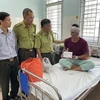 Lãnh đạo Chi cục Kiểm lâm Đồng Nai thăm hỏi, động viên kiểm lâm viên của Vườn Quốc gia Cát Tiên tại bệnh viện. (Ảnh: TTXVN phát)