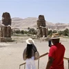 Khách du lịch ngắm Cặp tượng đá khổng lồ Memnon ở thành phố Luxor, Ai Cập. (Ảnh: AFP/TTXVN)