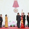 Chủ tịch Quốc hội Vương Đình Huệ gắn Huân chương Lao động hạng Nhì lên cờ truyền thống của Ban Công tác đại biểu. (Ảnh: Doãn Tấn/TTXVN)