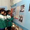 Các em học sinh tham quan trưng bày chuyên đề 'Đồng chí Nguyễn Lương Bằng - tấm gương người cộng sản mẫu mực.' (Ảnh: Mạnh Tú/TTXVN)