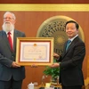 Phó Thủ tướng, Bộ trưởng Bộ Tài nguyên và Môi trường Trần Hồng Hà trao Huy chương Hữu nghị cho tiến sỹ Michael Parsons. (Ảnh: Hoàng Hiếu/TTXVN)