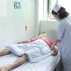 Nhân viên y tế Bệnh viện Chợ Rẫy đang theo dõi, điều trị tích cực cho bệnh nhân ngộ độc rượu nặng. (Ảnh: TTXVN phát)