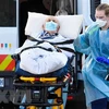 Nhân viên y tế chuyển bệnh nhân COVID-19 tại Melbourne, Australia. (Ảnh: AFP/TTXVN)