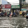 Nước ngập gần nửa bánh xe trên đường Lê Văn Thọ, quận Gò Vấp. (Ảnh: Hồng Giang/TTXVN)