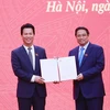 Thủ tướng Phạm Minh Chính trao Quyết định cho Bộ trưởng Bộ Tài nguyên và Môi trường Đặng Quốc Khánh. (Ảnh: Dương Giang/TTXVN)