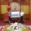 Tổng Giám đốc Thông tấn xã Việt Nam Vũ Việt Trang tặng bức ảnh Chủ tịch Hồ Chí Minh đến thăm Lạng Sơn cho Ủy ban Nhân dân tỉnh. (Ảnh: Anh Tuấn/TTXVN)