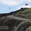 Quốc kỳ Azerbaijan (trái) và quốc kỳ Armenia tại trạm kiểm soát biên giới giữa hai nước ở làng Sotk (Armenia). (Ảnh: AFP/TTXVN)