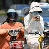 Người dân mặc áo chống nắng bảo vệ trong thời tiết nắng nóng gay gắt tại Thượng Hải, Trung Quốc. (Ảnh: AFP/TTXVN)