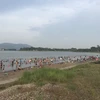 Rất đông người xuống tắm ở hồ Đại Lải, bất chấp cảnh báo nguy hiểm. (Nguồn: Vietnam+)