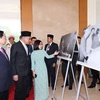Thủ tướng Phạm Minh Chính và Thủ tướng Malaysia Anwar Ibrahim tham quan trưng bày ảnh của Thông tấn xã Việt Nam. (Ảnh: Dương Giang/TTXVN)