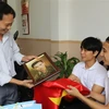 Đại diện nhóm TeamLee trao ảnh phục dựng truyền thần cho thân nhân liệt sỹ Nguyễn Chính (1937-1964). (Ảnh: Phan Sáu/TTXVN)