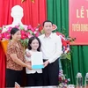 Chủ tịch UBND tỉnh Thanh Hóa Đỗ Minh Tuấn trao quyết định cho cô Lê Thị Thắm. (Ảnh: Hoa Mai/TTXVN)