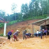 Người dân bản Nà Lếch, xã Chiềng Lao, huyện Mường La san gạt bùn, đất, đá bị sạt lở vào nhà. (Ảnh: Quang Quyết/TTXVN)