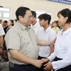 Thủ tướng Phạm Minh Chính với học sinh Trường Phổ thông Dân tộc Nội trú huyện Tu Mơ Rông. (Ảnh: Dương Giang/TTXVN)