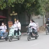 Học sinh đi xe máy điện không đội mũ bảo hiểm, dàn hàng ngang trên đường, tiềm ẩn nguy cơ mất an toàn giao thông. (Ảnh minh họa. Nguồn: TTXVN)