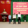 Tặng 'Huân chương Dũng cảm' của Chủ tịch nước cho đại diện gia đình anh Nguyễn Hữu Đốn. (Ảnh: Nguyễn Thanh/TTXVN)