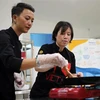 Đầu bếp Christine Ha (phải) và đầu bếp Tuyết Phạm - á quân MasterChef Việt Nam 2015 truyền cảm hứng nấu ăn cho các học viên. (Ảnh: Trần Lê Lâm/TTXVN)