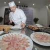 Đầu bếp Kazuhiro Matsuishi xử lý cá thát lát sống làm món sushi cá thát lát. (Ảnh: Duy Khương/TTXVN)