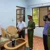 Cán bộ công an đọc lệnh khám xét, bắt tạm giam Nguyễn Đỗ Thúy Anh. (Ảnh: TTXVN phát)