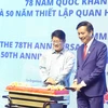 Đại sứ Đinh Ngọc Linh và Bộ trưởng Bộ Hợp tác và Phát triển Doanh nghiệp Malaysia Ewon Benedick tiến hành nghị thức cắt bánh chúc mừng. (Ảnh: An Nguyễn/TTXVN)