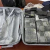 Các cọc tiền đôla giả trong valy của Việt và Tú bị phát hiện tại Sân bay quốc tế Tân Sơn Nhất. (Nguồn: Công an Nhân dân)