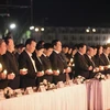 Các đại biểu thắp nến tưởng niệm các nạn nhân tử vong do tai nạn giao thông tại buổi lễ. (Ảnh: Trọng Đạt/TTXVN)