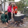 Bộ Chỉ huy Bộ đội Biên phòng tỉnh Kon Tum và bà con Gié Triêng tại làng Nông Kon, xã Đăk Dục cùng nhau luộc bánh chưng. (Ảnh: Khoa Chương/TTXVN)
