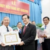 Ông Lê Hồng Quang, Bí thư Tỉnh ủy An Giang trao Huy hiệu Đảng cho các đảng viên cao niên tuổi Đảng. (Ảnh: Thanh Sang/TTXVN)