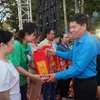 Ông Phạm Chí Tâm, Phó Chủ tịch Liên đoàn Lao động Thành phố Hồ Chí Minh tăng quà cho công nhân lao động. (Ảnh: Thanh Vũ/TTXVN)