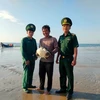 Cán bộ Đồn Biên phòng Phước Thuận tiếp nhận cá thể đồi mồi từ ngư dân Đỗ Xuân Ngọc. (Ảnh: TTXVN)