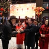 Chủ tịch UBND tỉnh Quảng Ninh Cao Tường Huy (thứ 2 bên phải) tặng hoa và lì xì cho du khách. (Ảnh: Đức Hiếu/TTXVN)