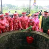 Các cụ cao niên thực hiện nghi thức lấy nước từ giếng Rồng. (Ảnh: Nguyễn Lành/TTXVN)