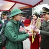 Thượng tướng Lương Tam Quang, Ủy viên Trung ương Đảng, Thứ trưởng Bộ Công an tặng hoa chúc mừng các tân binh. (Ảnh: Thế Duyệt/TTXVN)