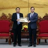 Chủ tịch UBND thành phố Đà Nẵng Lê Trung Chinh (bên phải) tặng quà lưu niệm cho ông Supasit Kocharoenyos, Tỉnh trưởng tỉnh Ubon Ratchathani của Thái Lan. (Ảnh: Trần Lê Lâm/TTXVN)