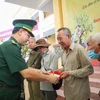 Đại tá Phạm Đình Triệu, Chính ủy Bộ đội Biên phòng Tây Ninh tặng quà cho người dân vùng biên giới. (Ảnh: Giang Phương/TTXVN)