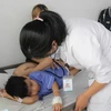 Bác sỹ Bệnh viện Đa khoa Tâm Trí Nha Trang kiểm tra sức khỏe cho bệnh nhi trong vụ ngộ độc thực phẩm. (Ảnh: Phan Sáu/TTXVN)