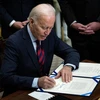 Tổng thống Mỹ Joe Biden ký phê chuẩn một dự luật tại Nhà Trắng ở Washington DC. (Ảnh: AFP/TTXVN)