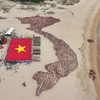 Đoàn viên thanh niên và học sinh tỉnh Phú Yên xếp hình bản đồ đất nước với hai quần đảo Hoàng Sa và Trường Sa bên cạnh cờ Tổ quốc. (Ảnh: TTXVN phát)