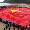 Lá cờ Tổ quốc rộng hơn 1.000m2 được trải dài tại Bãi Môn. (Ảnh: TTXVN phát)