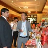 Đại biểu Ấn Độ tìm hiểu về sản phẩm càphê của tỉnh Đắk Lắk. (Ảnh: Tuấn Anh/TTXVN)