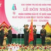 Trung tướng Nguyễn Anh Tuấn, Chính Ủy Bộ đội biên phòng gắn Huân chương Bảo vệ Tổ quốc hạng Nhất lên Cờ truyền thống của Cục Chính trị Bộ đội biên phòng. (Ảnh: Trọng Đức/TTXVN)