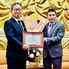Chủ tịch Liên hiệp Các tổ chức hữu nghị Việt Nam Phan Anh Sơn trao Kỷ niệm chương cho Đại sứ Yamada Takio. (Ảnh: Việt Đức/TTXVN)